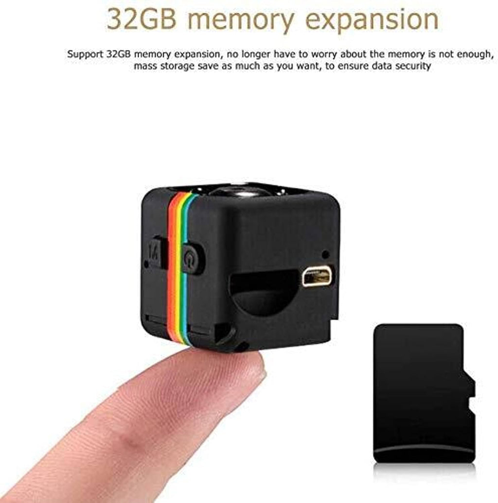 A small black cube-shaped memory expansion module with a rainbow stripe detail, shown resting on a person's finger to demonstrate its compact size, alongside a separate black memory card and text at the top stating '32GB memory expansion'.