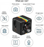 A small black cube-shaped security camera with a rainbow stripe detail, surrounded by feature icons and text on a white background. The text highlights features such as photo camera, motion detection, web camera, IR night vision, full HD 1080P, 100 mins recording time, and sound recorder, and states it accepts 32GB TF Card.